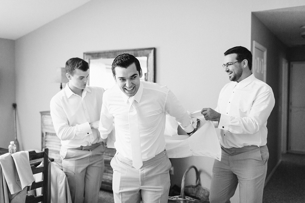 Groom and groomsmen putting on suits at Higuera Ranch wedding in San Luis Obispo, CA