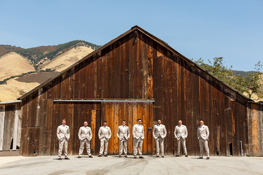 Groomsmen taking photos in front of the barn at Higuera Ranch in San Luis Obispo