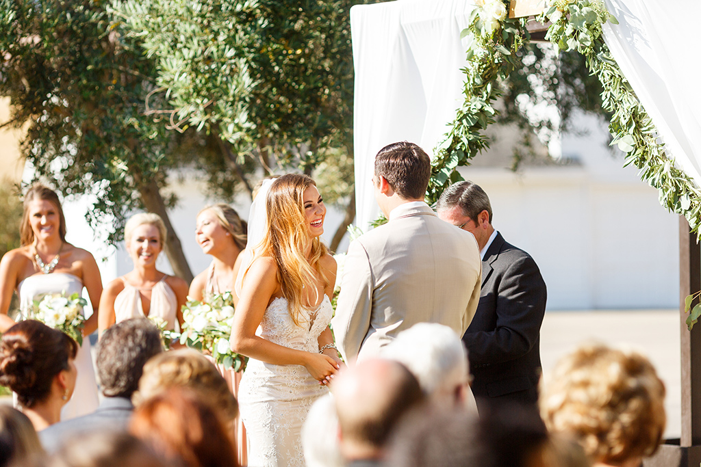 Bride and groom laughing during their ceremony at Higuera Ranch