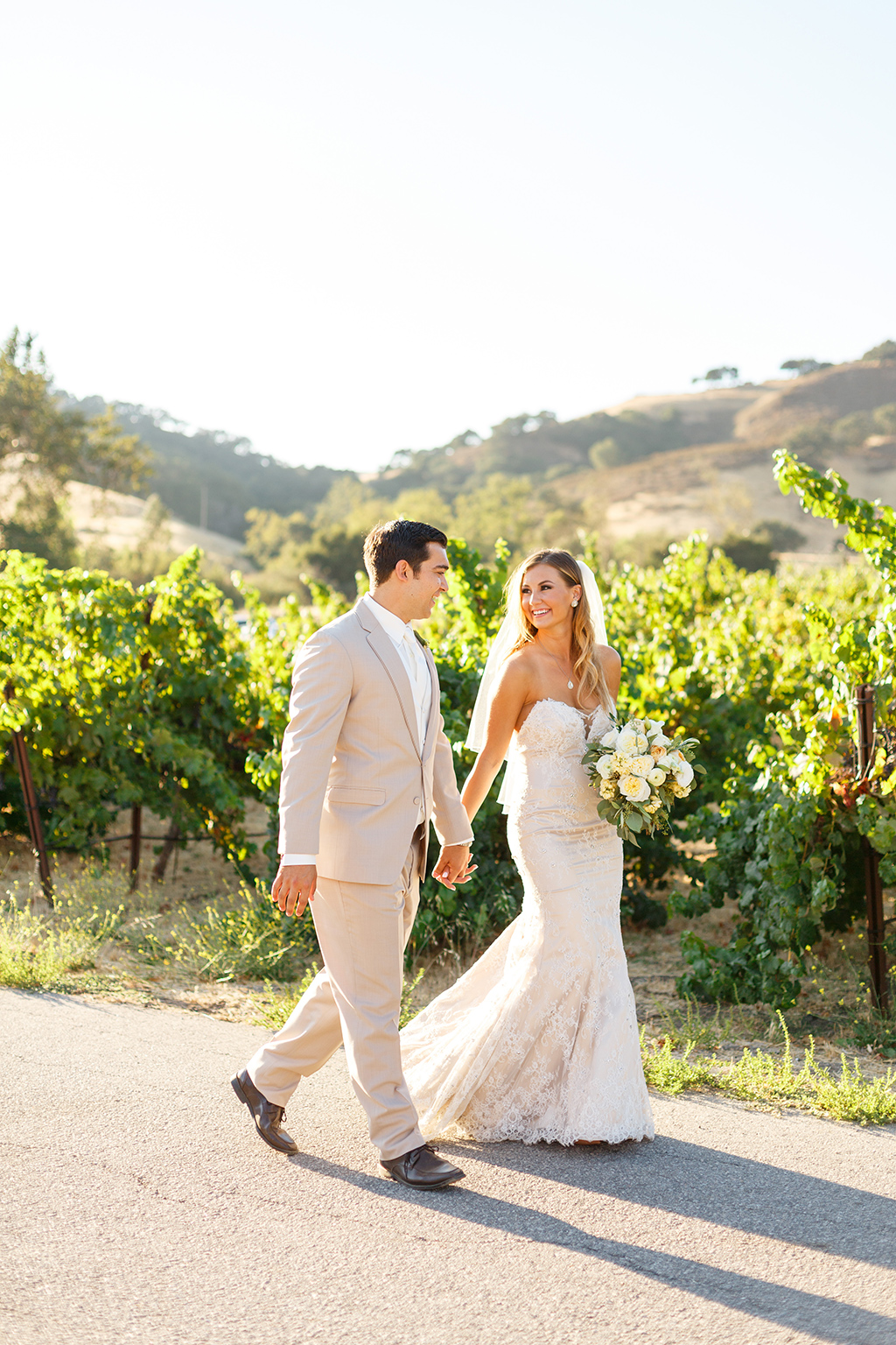 Bride and groom walking hand in hand at Higuera Ranch in San Luis Obispo, CA