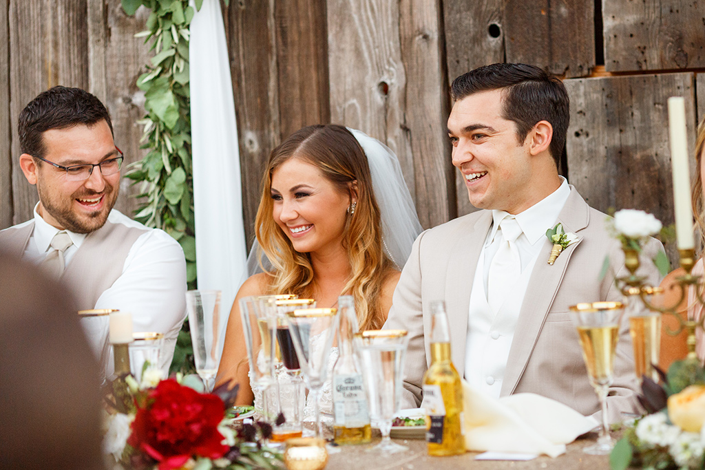 Bride and groom laughing during toasts at their Higuera Ranch wedding