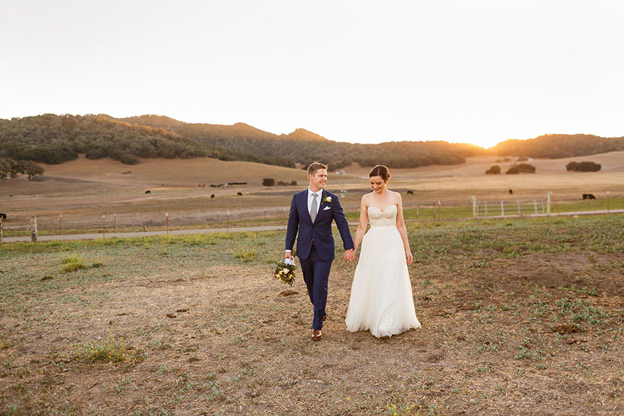 Sunset photos walking hand in hand with bride and groom at wedding at Thousand Hills Ranch