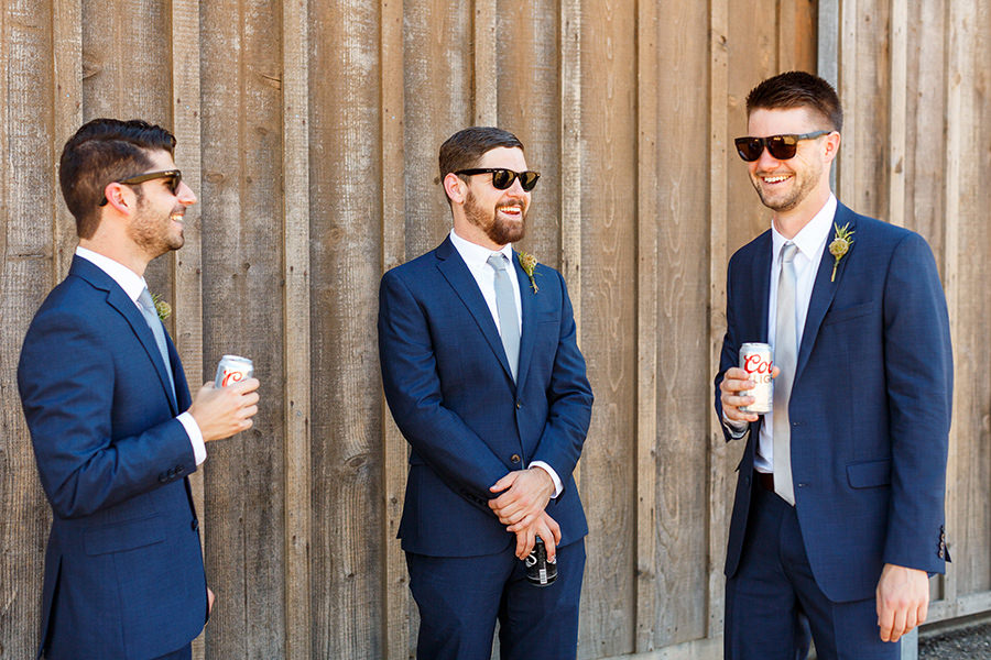 Groomsmen hanging out in front of barn