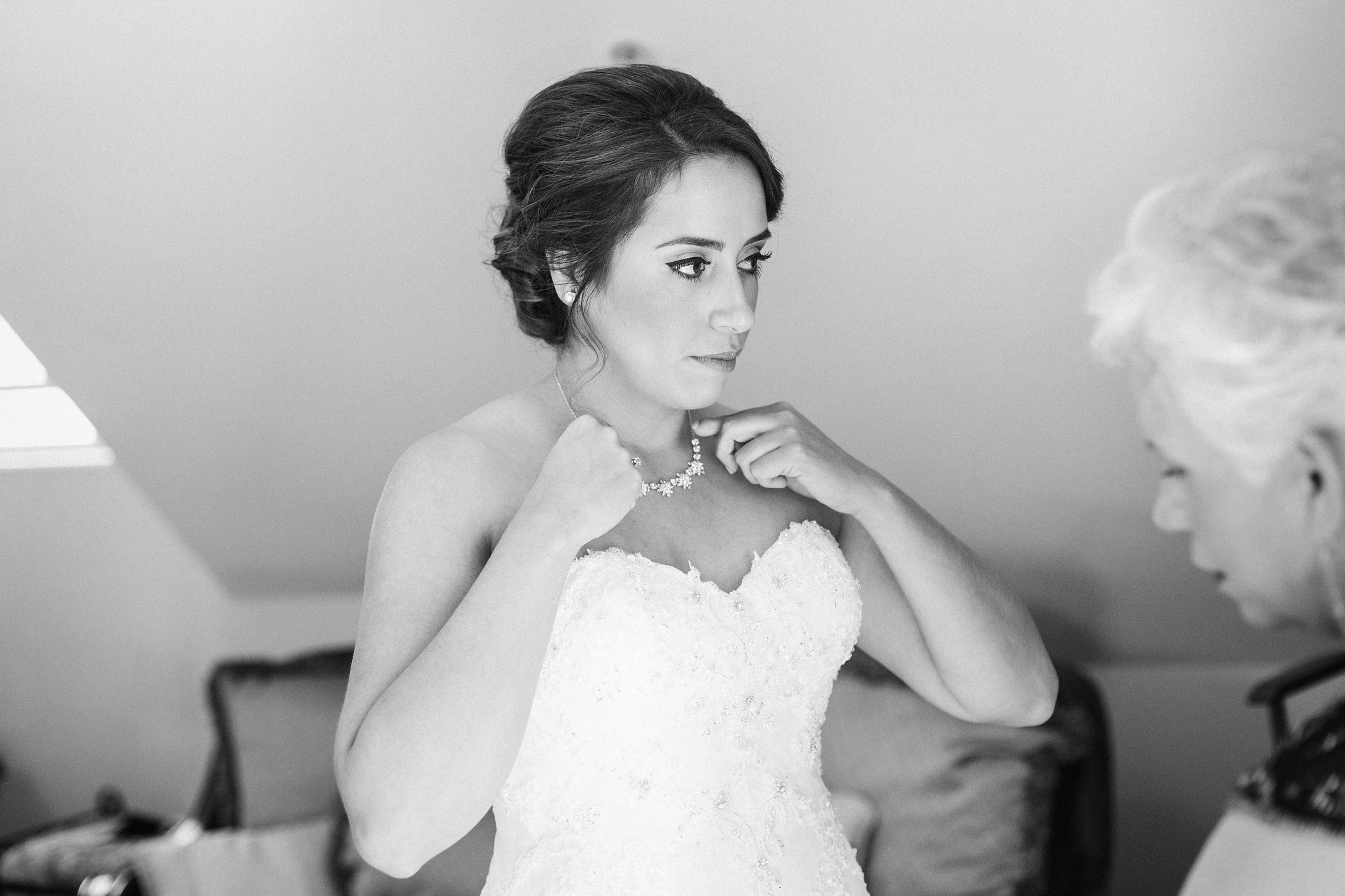 Bride puts on her necklace before her Spanish Oaks Ranch wedding