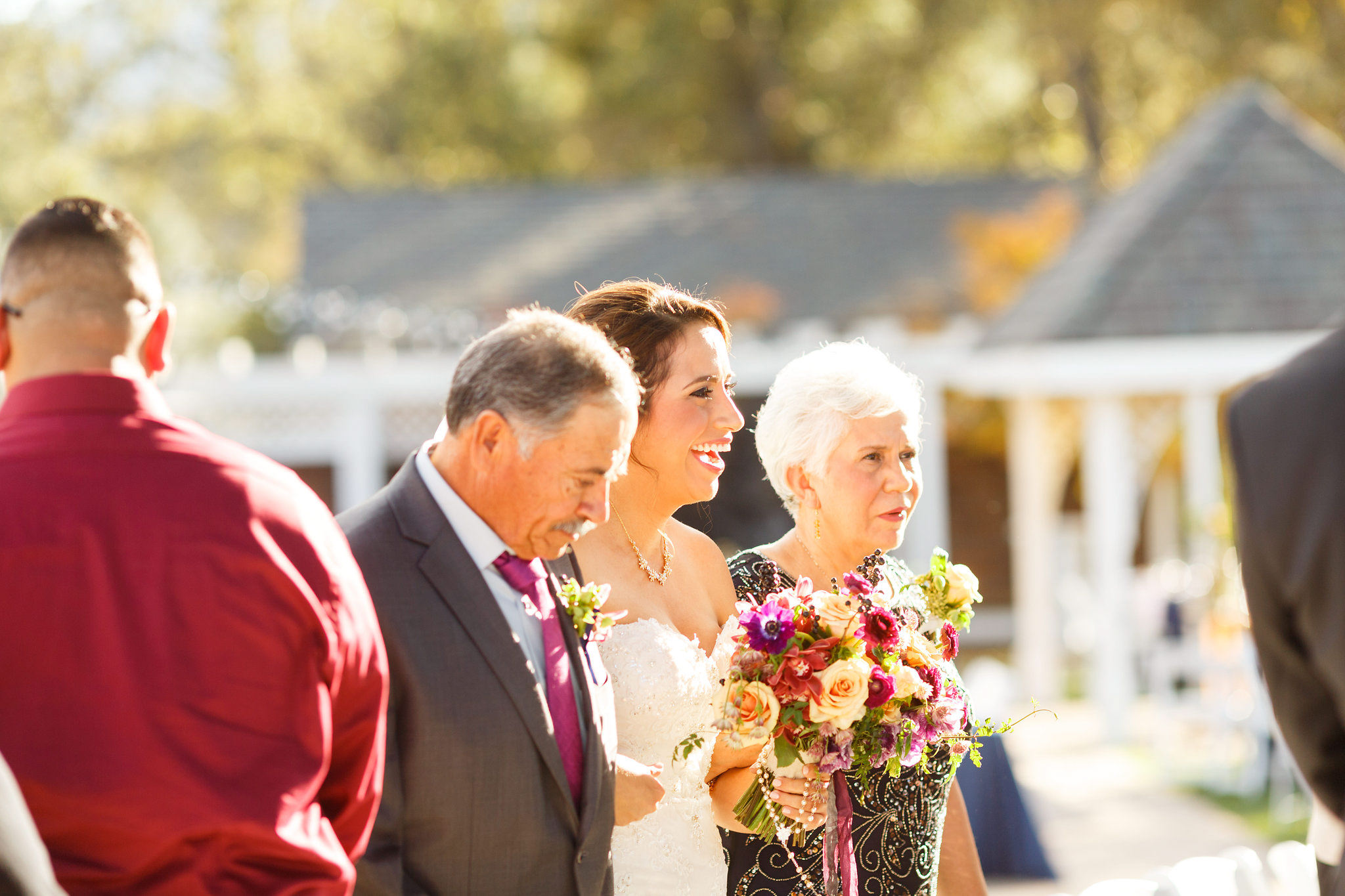 Bride and walks down the aisle with her parents at Spanish Oaks Ranch wedding
