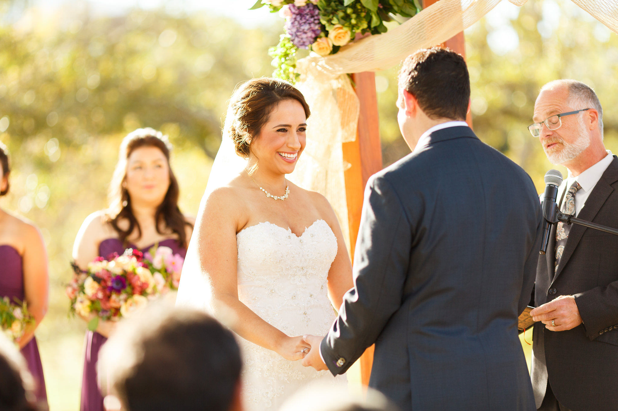Bride and groom holding hands during ceremony at Spanish Oaks Ranch wedding