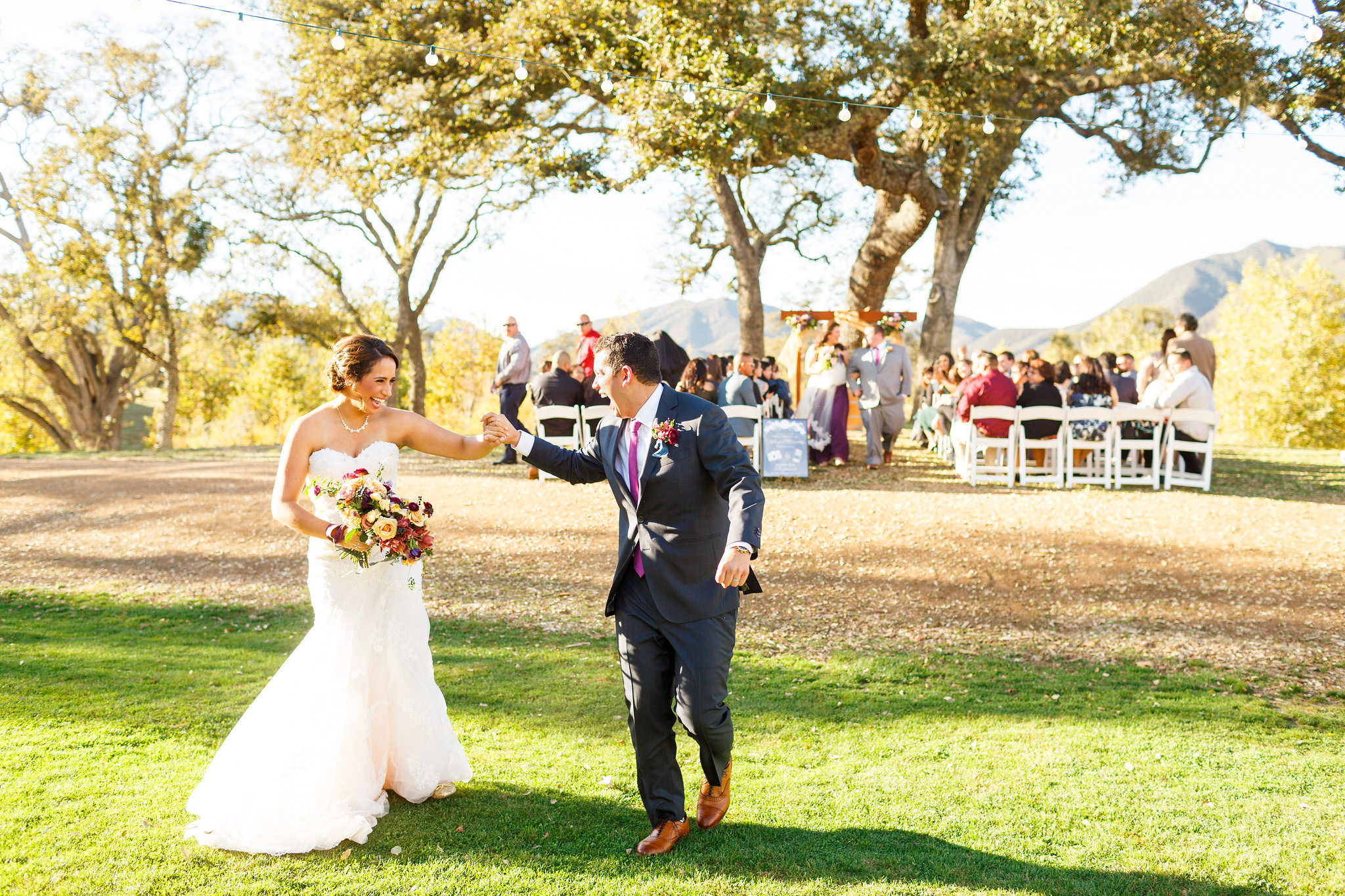Bride and groom celebrate after walking down the aisle at Spanish Oaks Ranch.